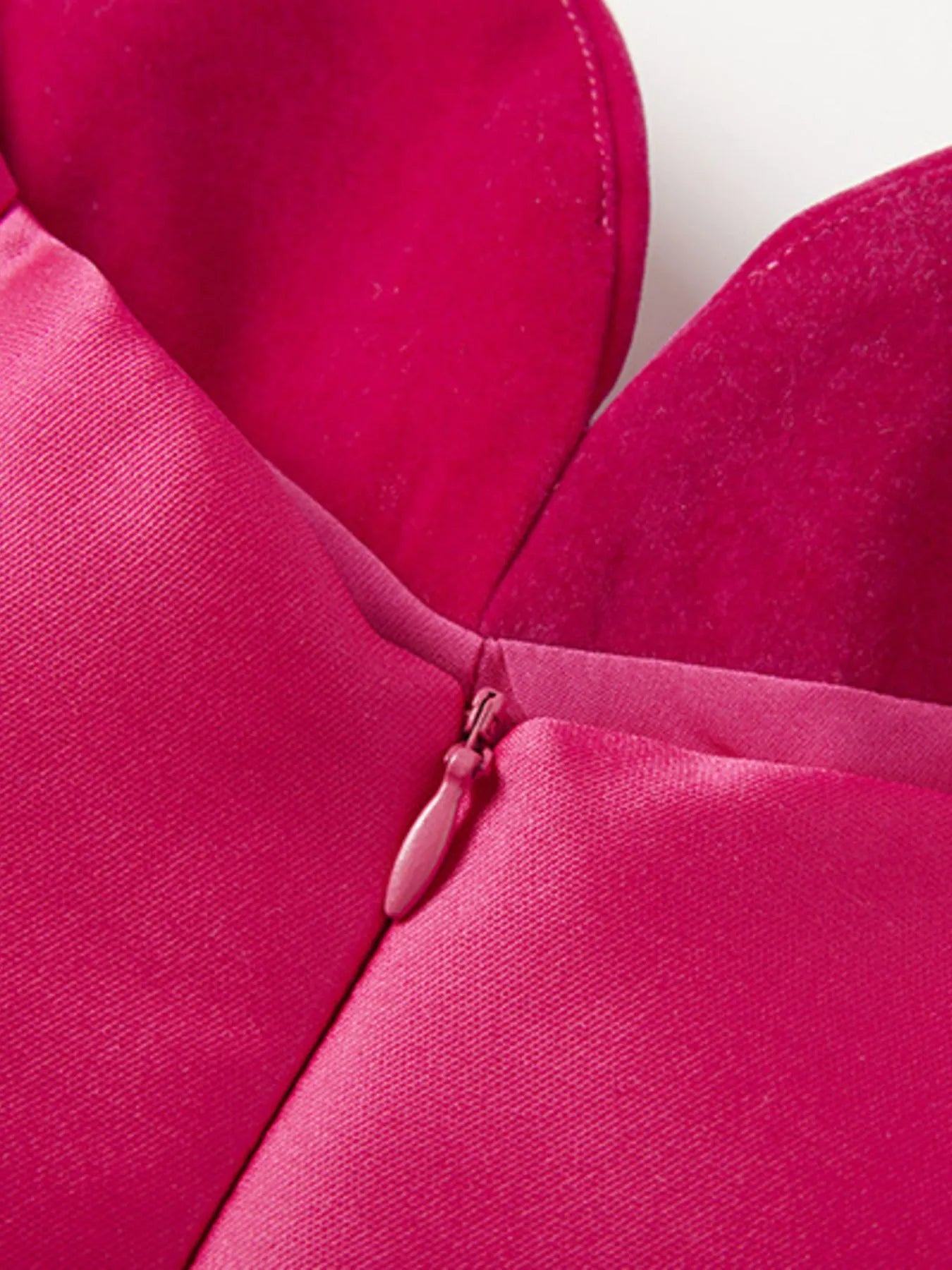 Close-up of a rose red dress top with a zipper on a white background