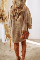 Woman wearing a tan cable knit long sleeve sweater dress styled with knee-high brown boots and layered gold necklaces.