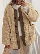 Women's tan sherpa jacket with contrasting ribbed trim, round neckline, front buttons, and patch pockets, layered over a cream sweater.