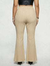 Model wearing tan plus-size high-waisted flare pants styled with pointed-toe heels for an elegant and sophisticated look.