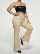 Model wearing tan plus-size high-waisted flare pants styled with pointed-toe heels for an elegant and sophisticated look.