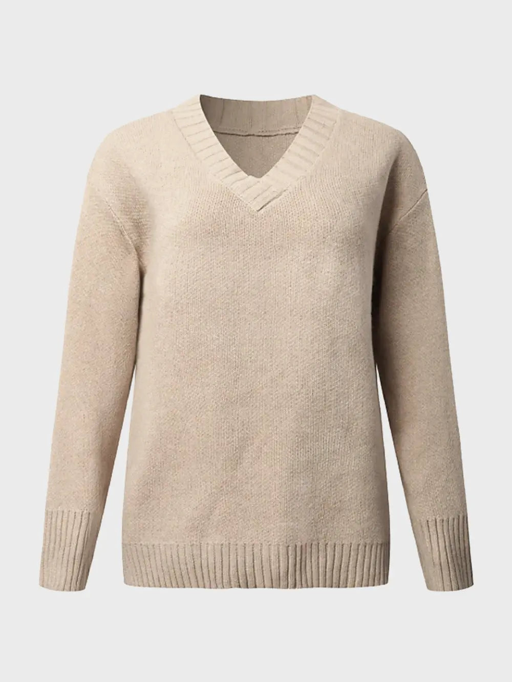 Woman wearing a tan V-neck long sleeve knit top with ribbed neckline and cuffs, styled with black denim shorts.