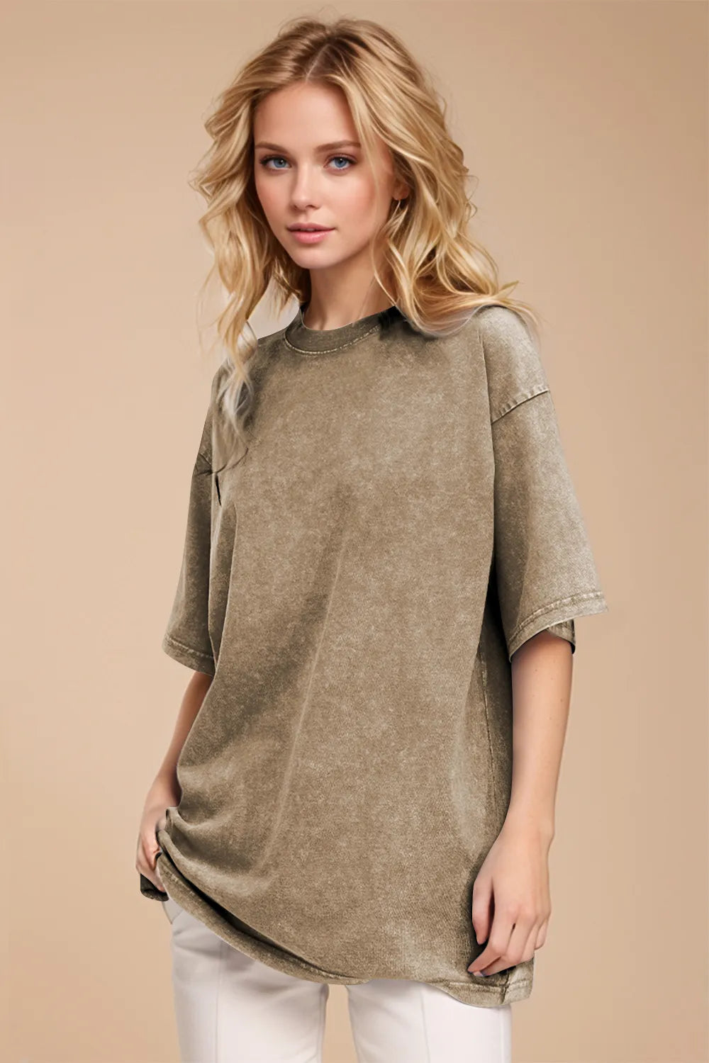 Woman wearing an oversized taupe Basic Bae round-neck half-sleeve T-shirt styled with dark denim jeans and a long pendant necklace for a relaxed, casual look.