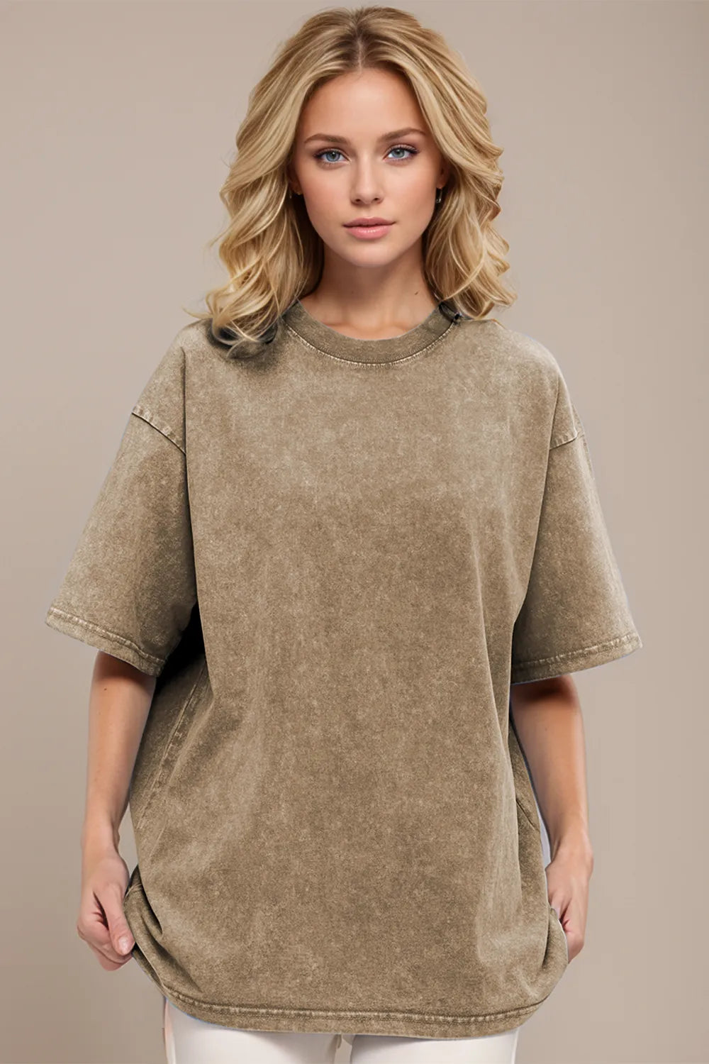 Woman wearing an oversized taupe Basic Bae round-neck half-sleeve T-shirt styled with dark denim jeans and a long pendant necklace for a relaxed, casual look.