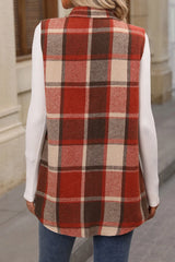 Woman wearing a terracotta plaid button-up vest coat layered over a white turtleneck with blue jeans and gold jewelry for a cozy fall outfit.