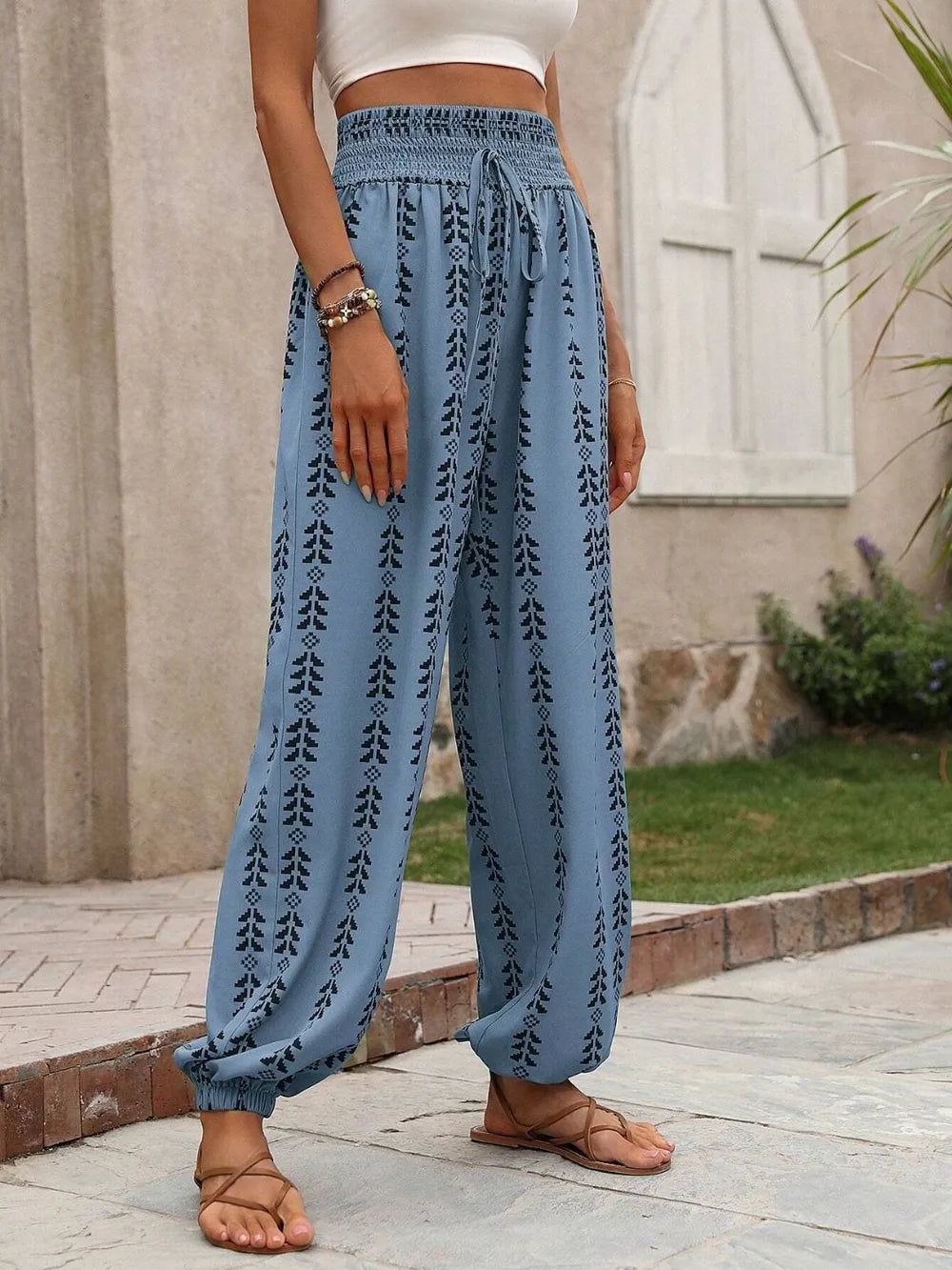 Person wearing cerulean patterned pants standing outdoors on a stone path.