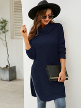 Woman wearing a dark blue turtleneck waffle-knit slit sweater dress with long sleeves and a relaxed fit for fall.