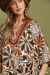 Woman wearing a patterned dress with a brown and beige design against a green background