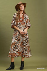 Woman wearing a patterned dress and hat on a green background
