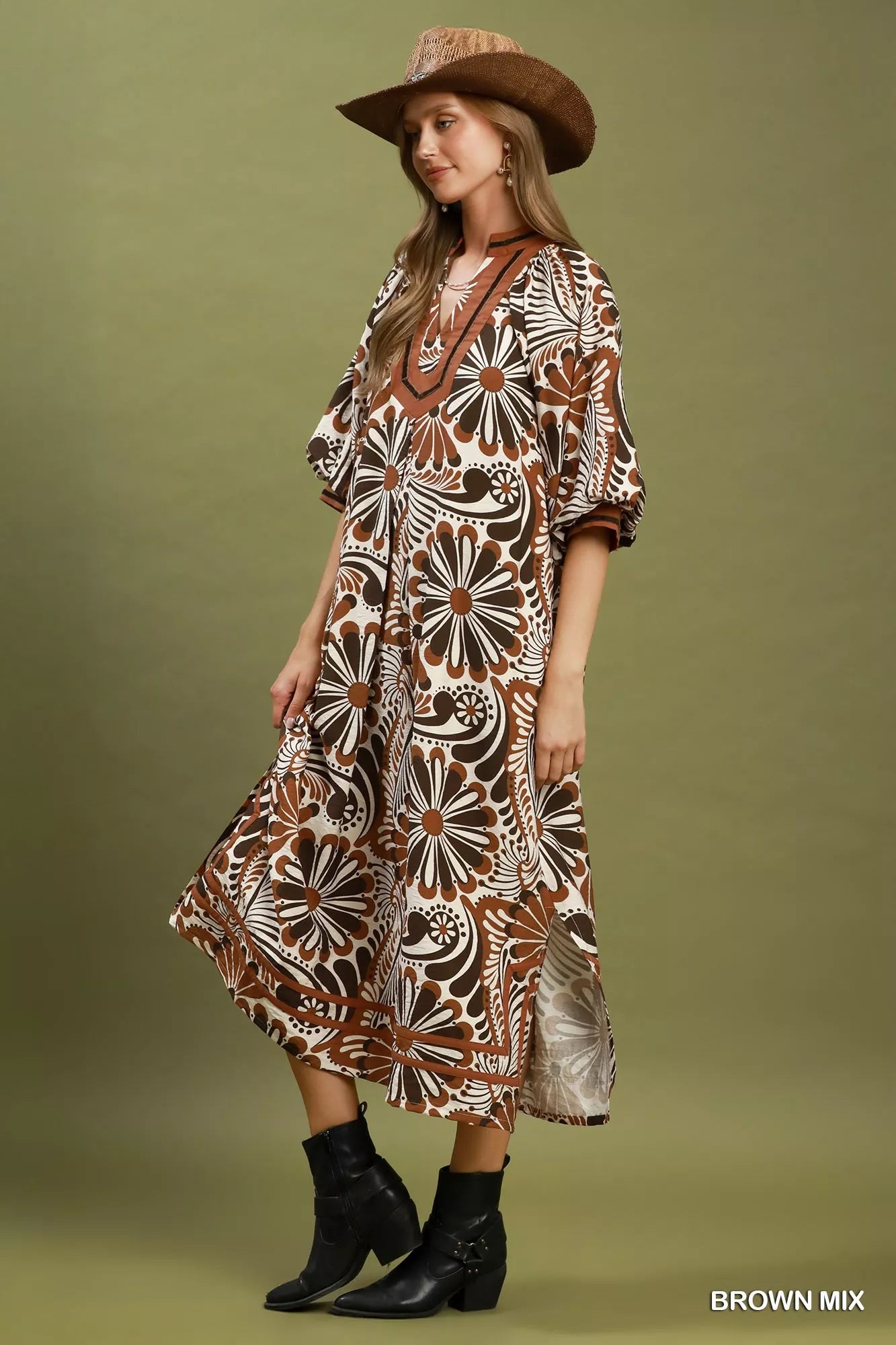 Woman wearing a patterned dress and cowboy hat on a green background