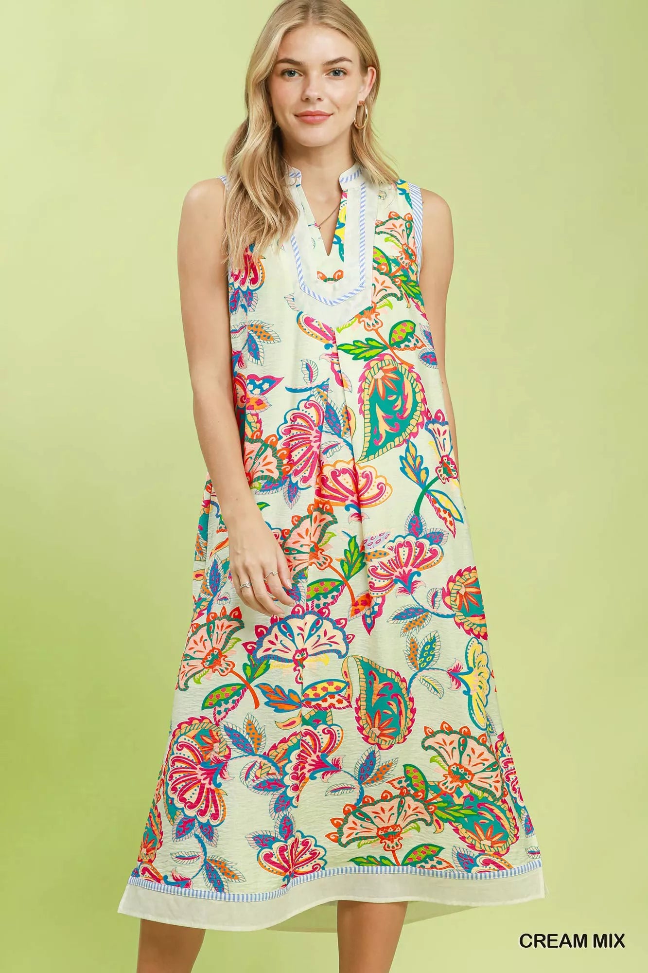 Woman wearing a colorful floral dress on a light green background