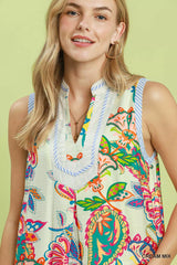 Woman wearing a colorful floral dress against a light green background