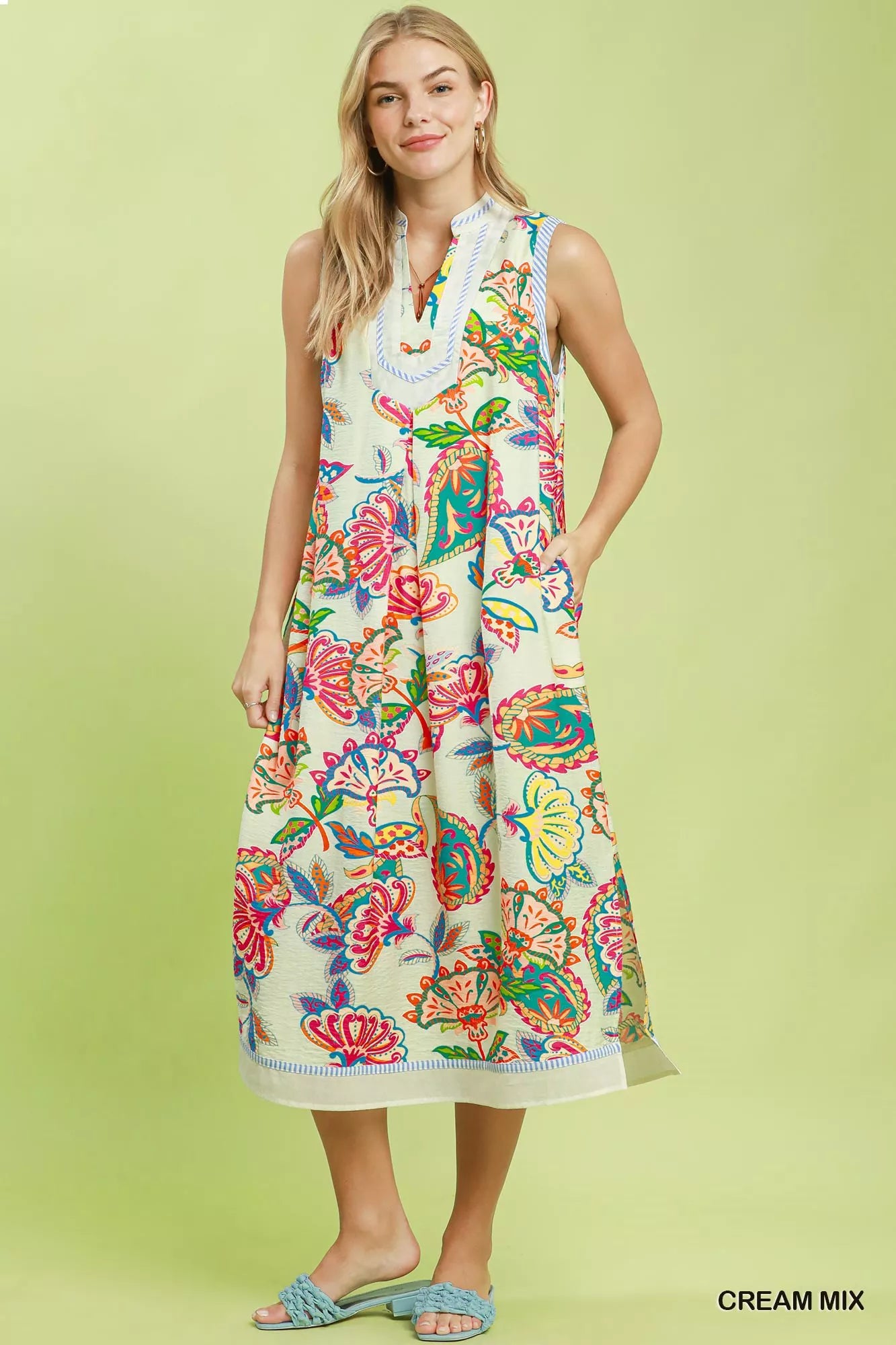 Woman wearing a colorful floral dress on a light green background