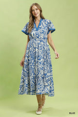 Woman wearing a blue and white patterned dress on a green background