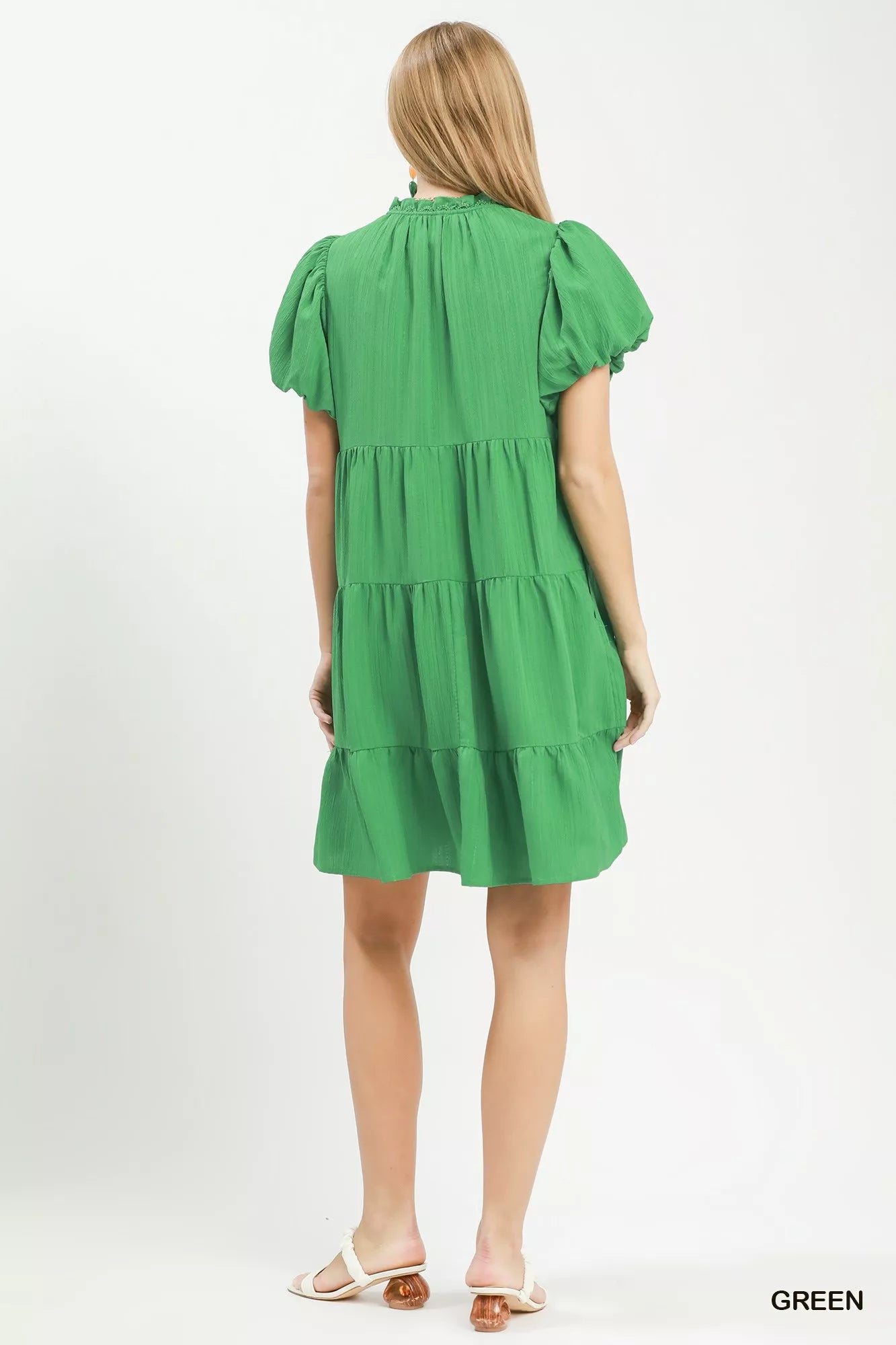 Green dress worn by a model on a white background