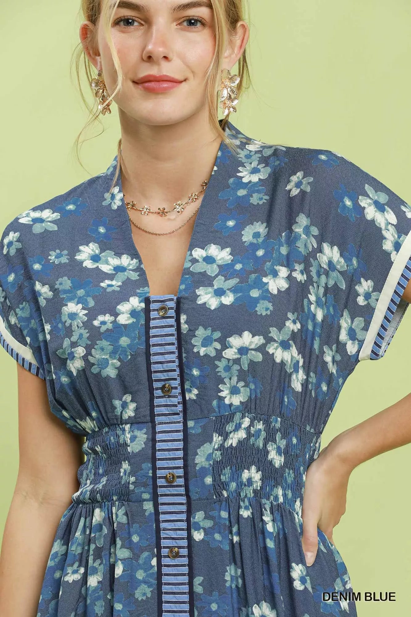 Woman wearing a blue floral dress with a green background