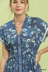 Woman wearing a blue floral dress with a green background