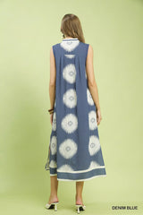 Woman wearing a denim blue dress with white floral patterns on a light green background