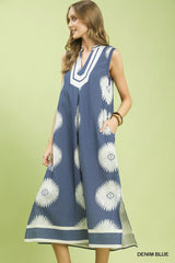 Woman wearing a denim blue dress with white floral patterns on a light green background
