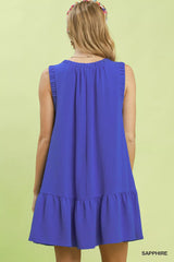 Blue dress with ruffled hem on a green background