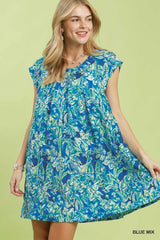 Woman wearing a blue floral dress on a green background