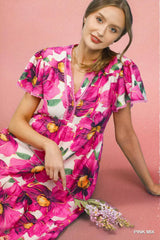 Woman wearing a pink floral dress against a pink background
