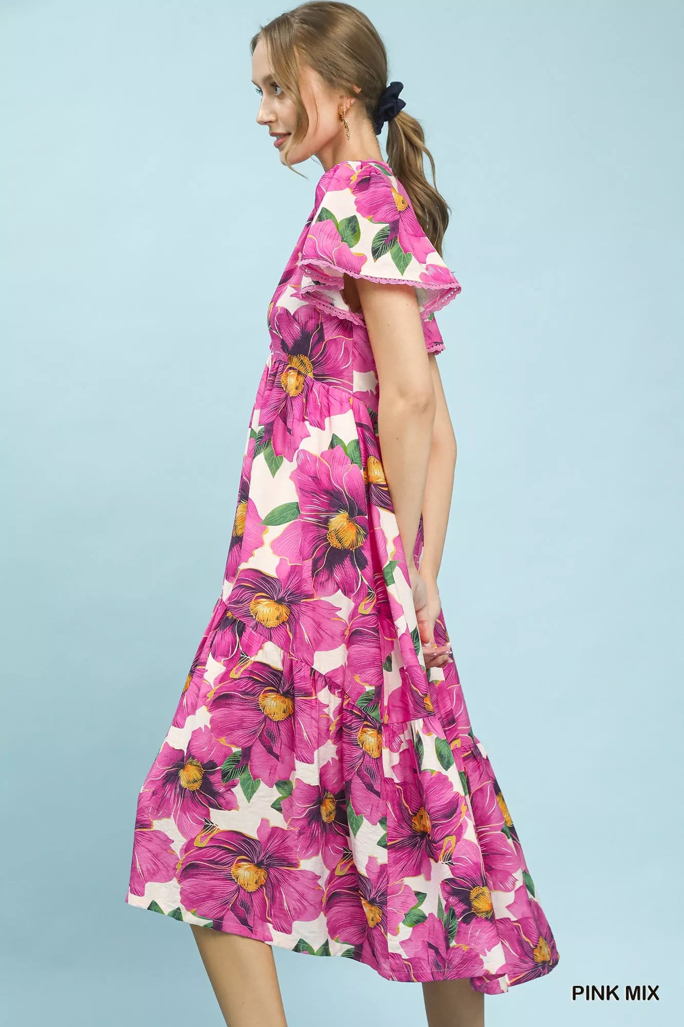 Woman wearing a pink floral dress on a light blue background