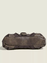 Brown leather duffel bag on a beige background
