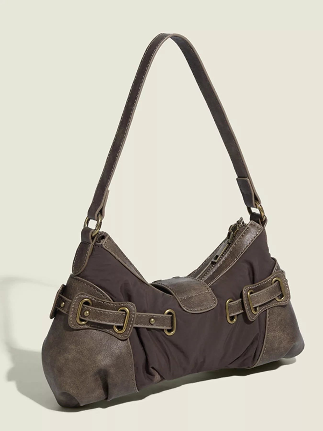 Brown handbag with leather straps on a beige background