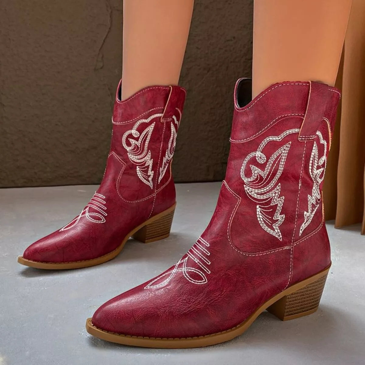 Women's red Western cowboy boots with classic embroidered detailing and comfortable mid heel.
