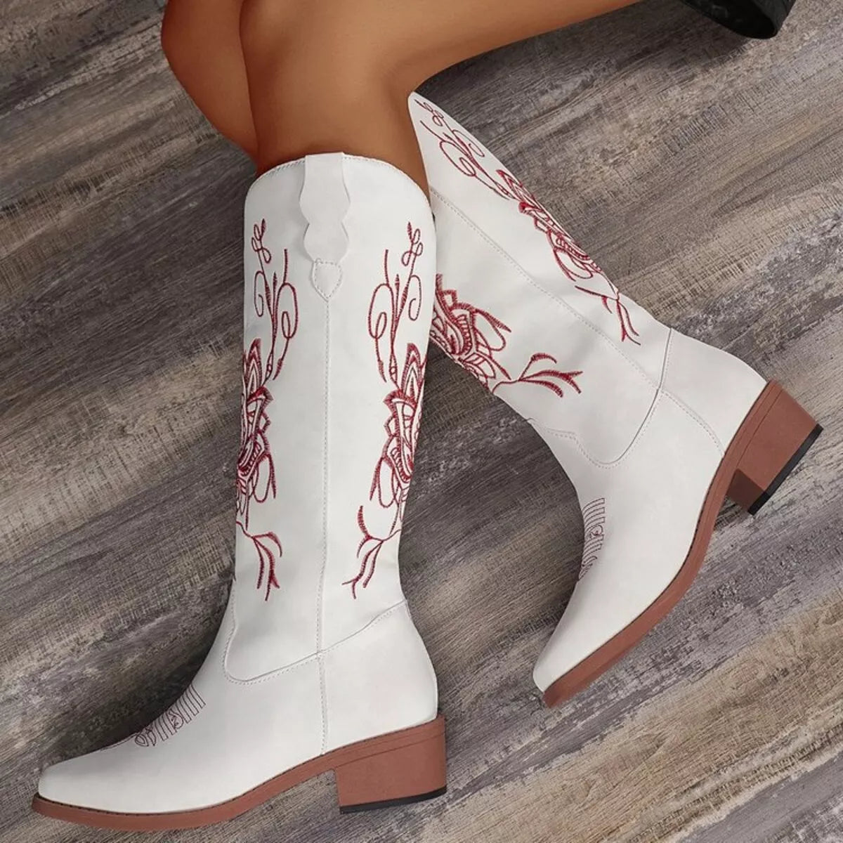 Women’s white Western cowboy boots with red embroidered detailing and mid-height block heels.