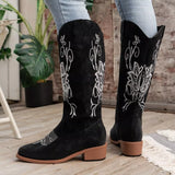 Women’s black Western cowboy boots with white embroidered detailing and mid-height block heels.
