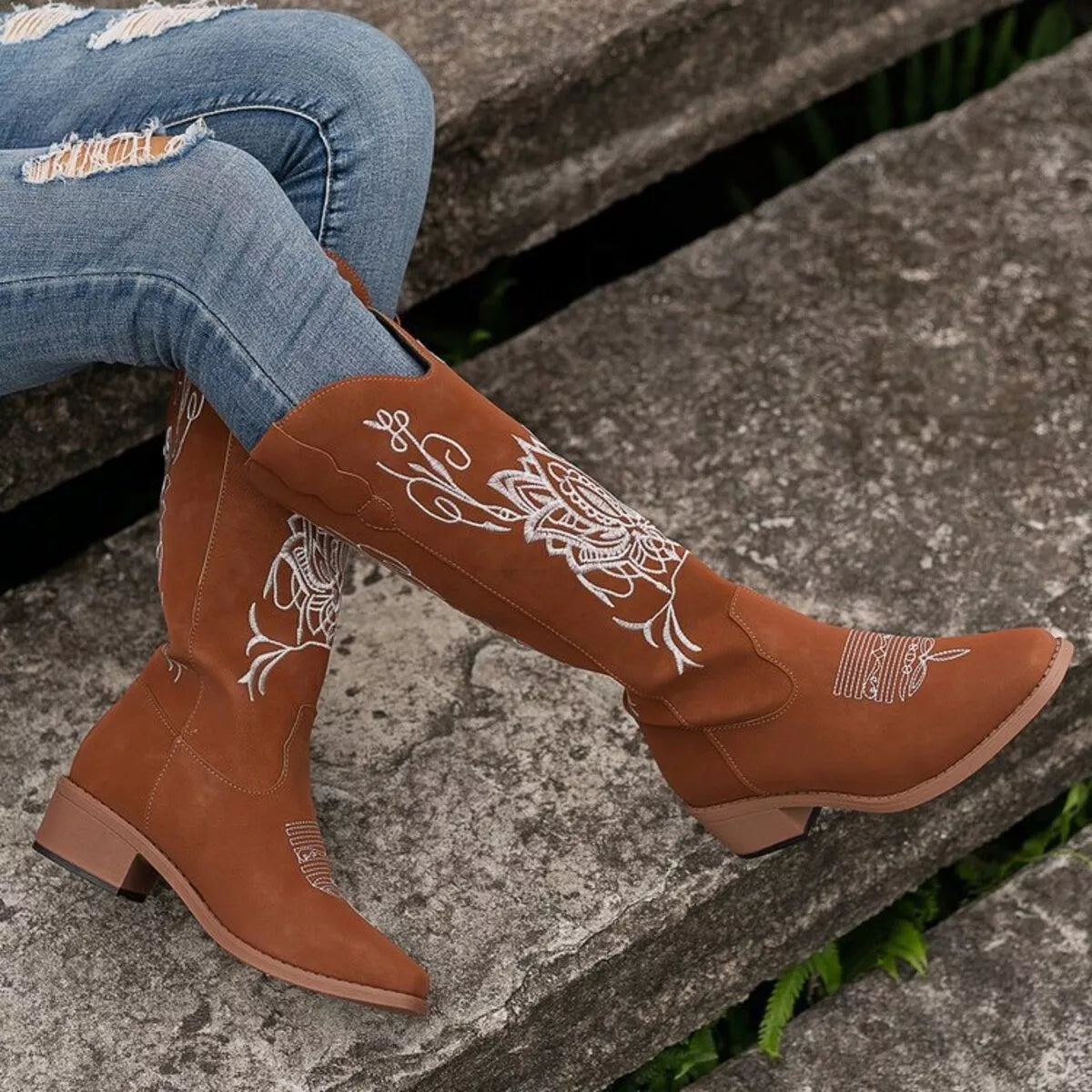 Women’s dark brown Western cowboy boots with white embroidered detailing and mid-height block heels.