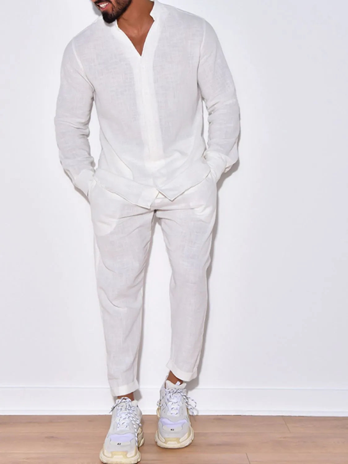Men’s white button up long sleeve top and matching pants two-piece set styled with white sneakers, available in sizes Small–2XL.