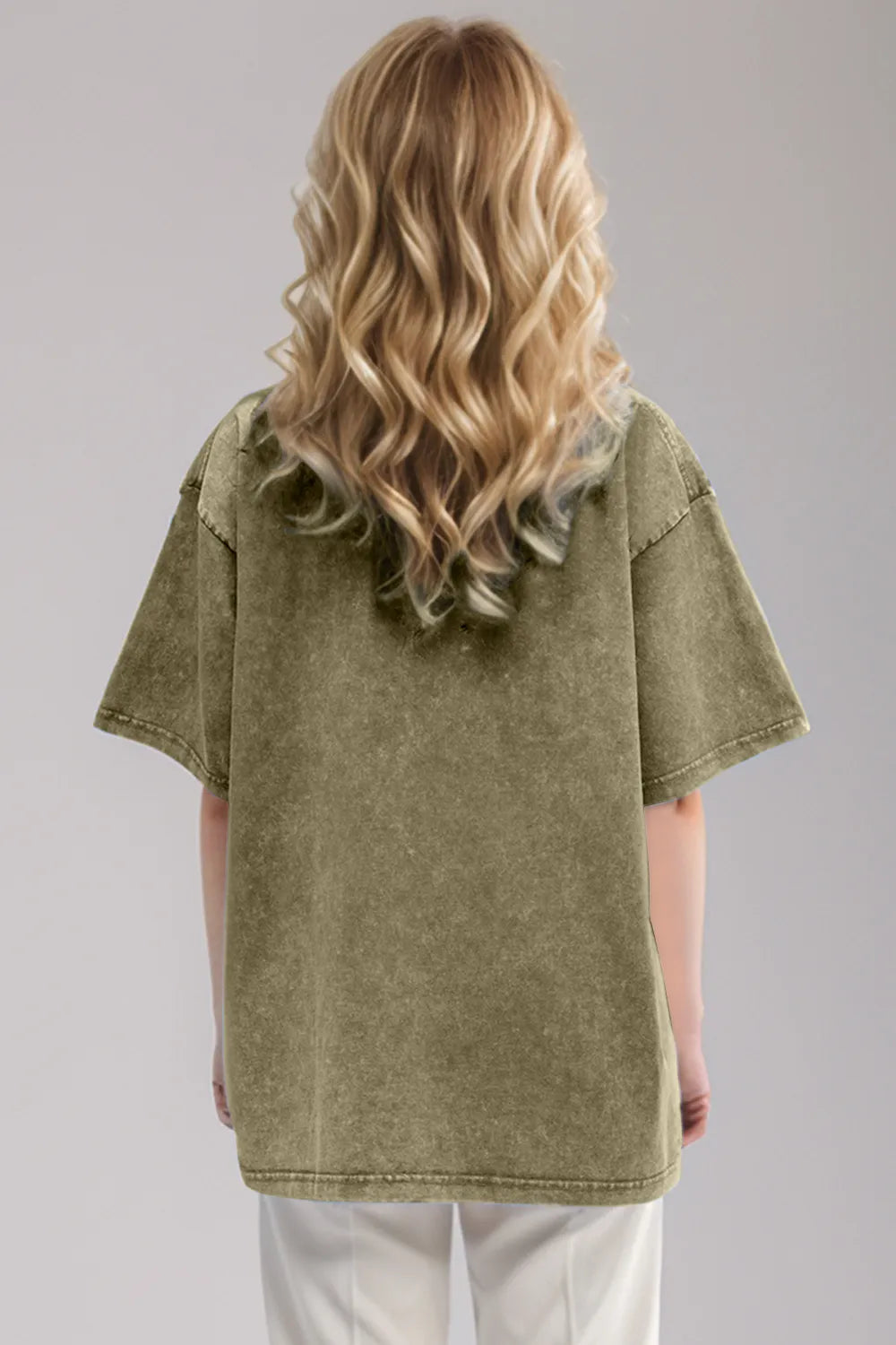 Woman wearing an oversized yellow-green Basic Bae round-neck half-sleeve T-shirt styled with dark denim jeans and a long pendant necklace for a relaxed, casual look.