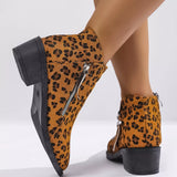 Woman wearing yellow leopard-print ankle boots with block heels and side zipper details.