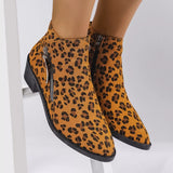 Woman wearing yellow leopard-print ankle boots with block heels and side zipper details.