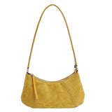 Yellow suede vintage-style shoulder bag with a minimalist silhouette paired with a neutral outfit.