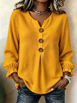 Women’s yellow waffle knit flounce sleeve top with button front detail and ruffled cuffs.