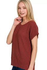 Woman wearing a rust-colored knit top on a white background