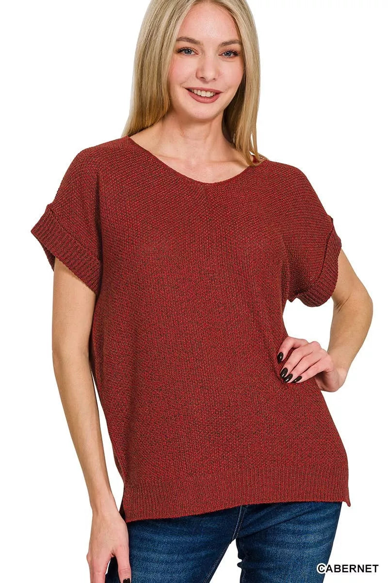 Woman wearing a red sweater with a plain background