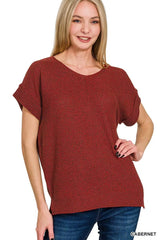 Woman wearing a red sweater with a plain background